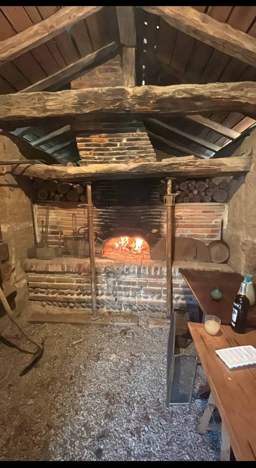 Le four à pain en pierre allumé sous sa charpente